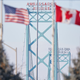 The American and Canadian flags fly at the Ambassador Bridge border crossing in Windsor, Ontario, Canada, on February 9, 2022. - Protestors, who are in support of the Truckers Freedom Convoy in Ottawa, have blocked traffic in the Canada bound lanes of the bridge since Monday evening. Approximately $323 million worth of goods cross the Windsor-Detroit border each day at the Ambassador Bridge, making it North Americas busiest international border crossing.